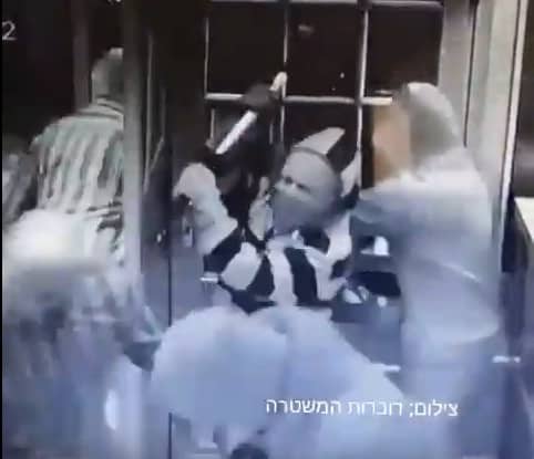 אחד השודדים מניף את הפטיש במהלך ניסיון השוד