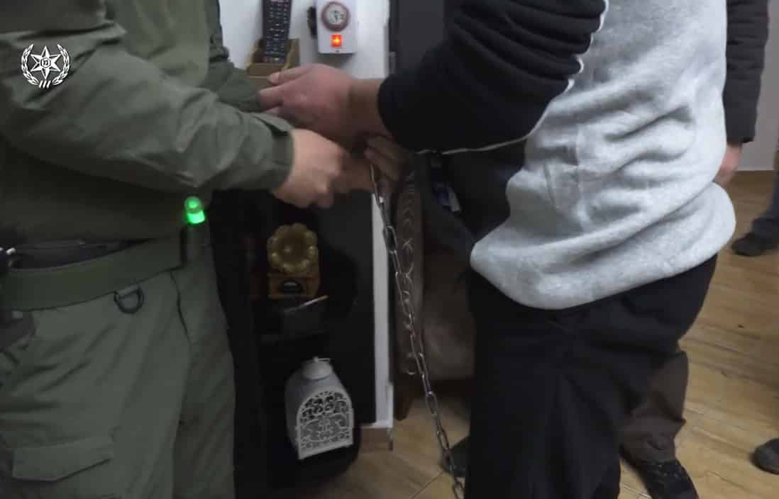 אחד החשודים בעת מעצרו בזמן הפשיטה (צילומים: דוברות המשטרה)