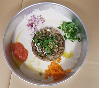 חציל ומעליו בצל ירוק, מסביב טחינה, מעליה גרידת עגבניות, בצל סגול, גמבה כתומה