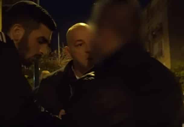 אחד הנאשמים (בגבו למצלמה) בעת מעצרו (לחצו כאן לתיעוד המעצרים בפרשה)